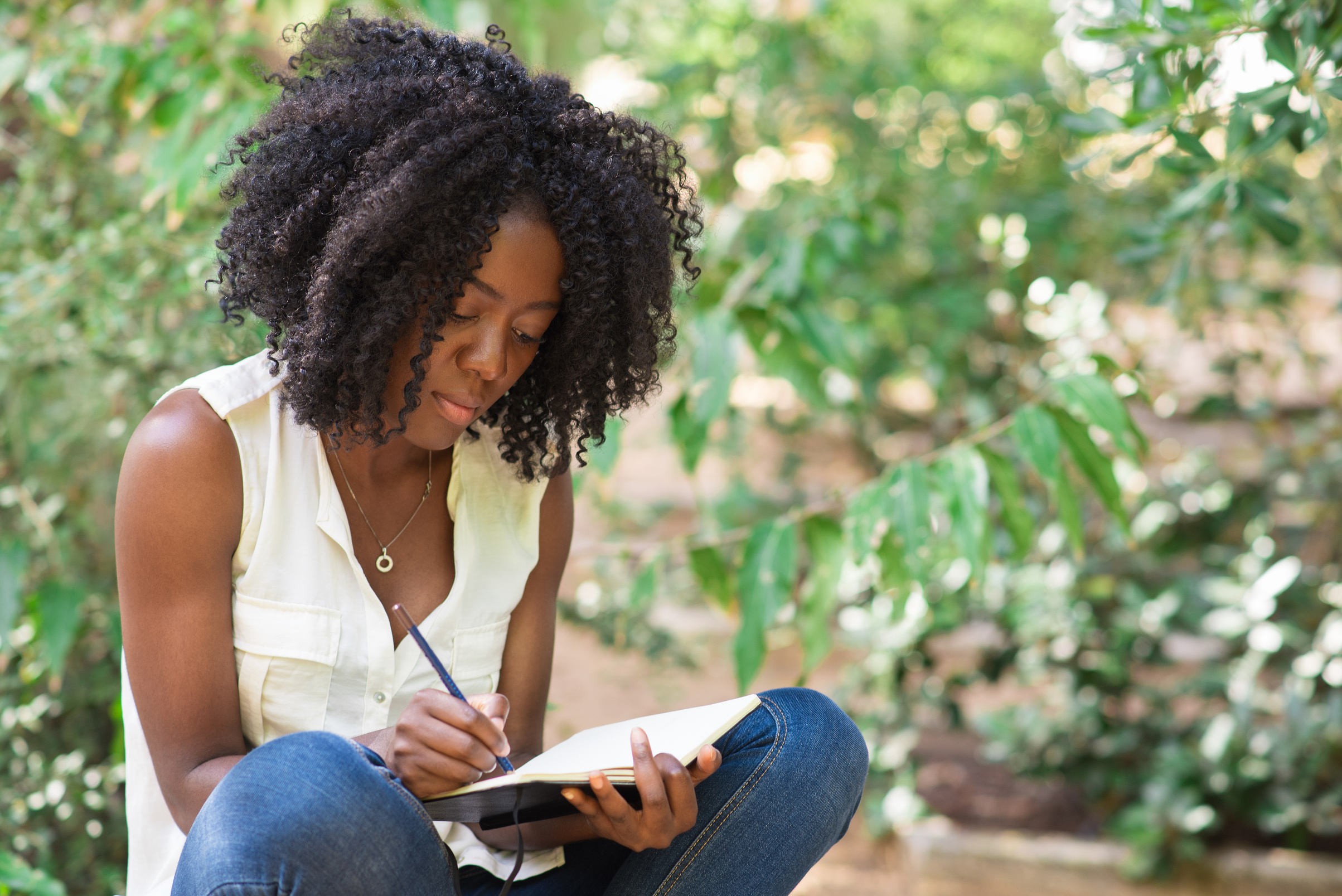 Serious Young Black Woman Working in Park